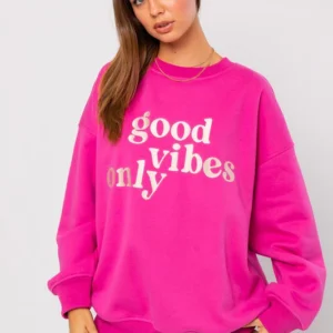 Woman wearing pink good vibes only sweatshirt.