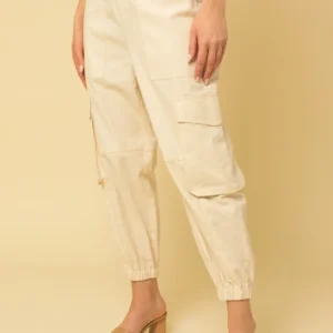 A woman wearing white pants and heels.