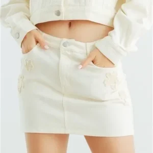 A woman wearing white denim skirt and jacket.