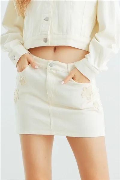 A woman wearing white denim skirt and jacket.