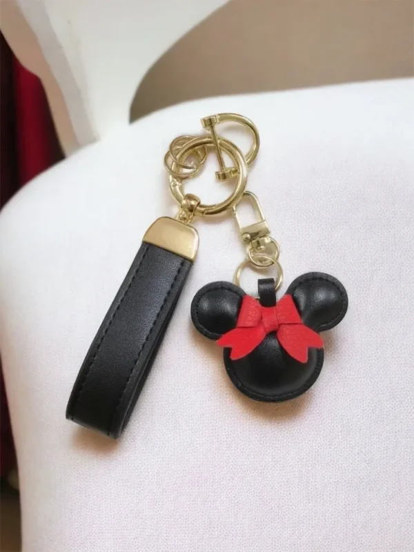 A mickey mouse keychain and key chain on top of a chair.