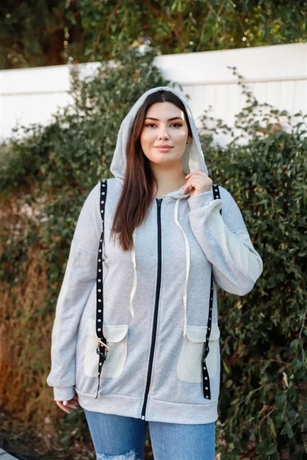 A woman wearing a white jacket and black chain.