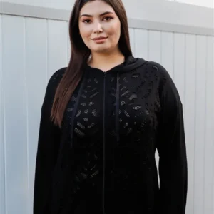 A woman wearing black and standing outside.