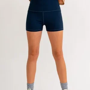 A woman wearing blue shorts and socks.