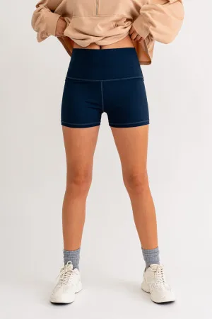 A woman wearing blue shorts and socks.