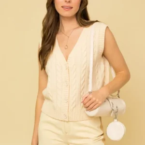 A woman in white outfit holding a purse.