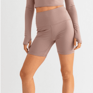 Woman wearing brown biker shorts and a long sleeve shirt.