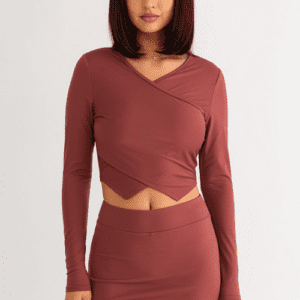 Woman in maroon crop top and skirt.
