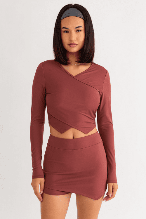 Woman in maroon crop top and skirt.