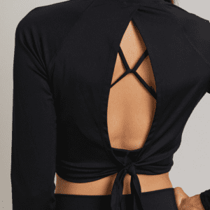 Woman wearing black long-sleeve top with open back.