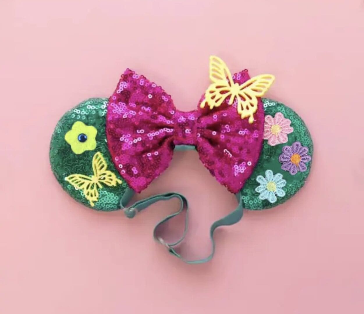 Green and pink sparkly mouse ears with flowers and butterflies.