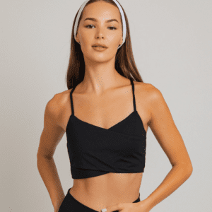 Woman in black sports bra with white headband.