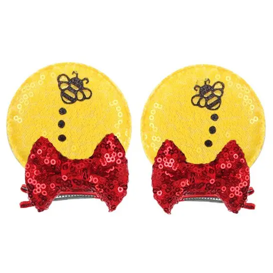 Yellow bee ear clips with red bows.